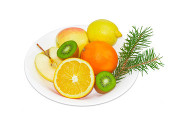 Different fruits on a white dish and fir branch