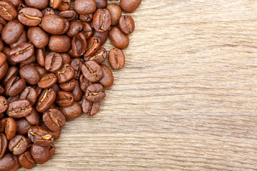 Roast coffee beans on wood background.