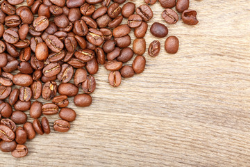 Coffee grains on grunge wooden background.