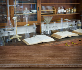 Wooden table over defocused vintage chemical laboratory background
