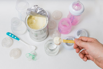 Fototapeta na wymiar Hand is prepairing milk formula for feeding baby from bottle.