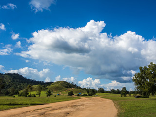 Fototapeta na wymiar soid road toward green hill with blue sky
