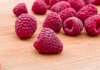 Ripe sweet raspberries on wood table close-up