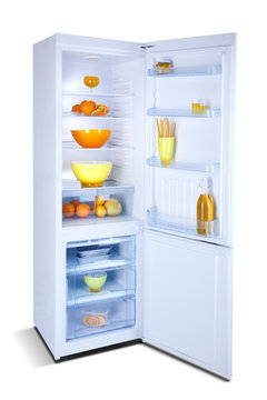 Refrigerator open with fresh food. Isolated on white