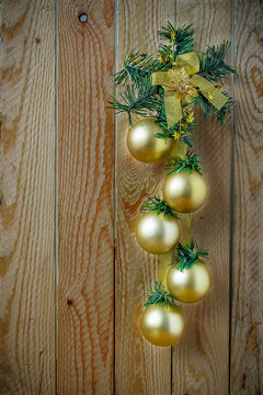 Gold Christmas balls hanging on dark wooden background