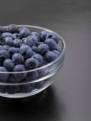 ripe blueberries in bowl isolated on black