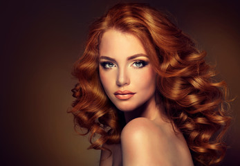 Girl model with long red wavy hair. Big curls on the red head . Hairstyle  permanent waving