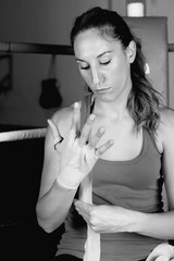 Female boxer tying up her hands