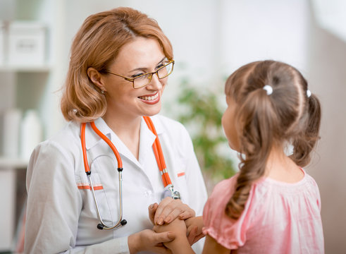 Positive pediatrician doctor examining kid