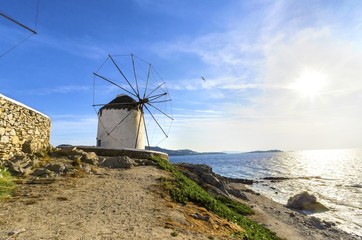 A windmill in Chora,Mykonos,Greece at sunset.Traditional greek whitewashed architecture,popular landmark,tourist attraction against the blue sky and the Aegean sea. The wind mills are now decorative. © f8grapher