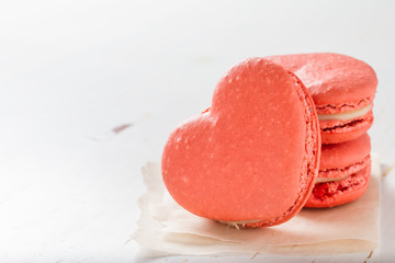 Heart shaped macaroon on white wood background