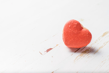 Heart shaped macaroon on white wood background