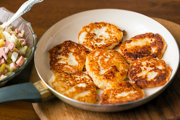 Golden pancakes in a frying pan. Cottage cheese fritters
