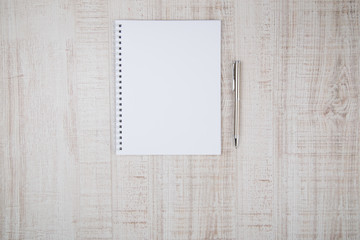 blank notebook with pen on wooden table