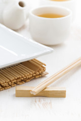 table setting for a Japanese meal on a white wooden background