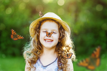 Laughing little girl with a butterfly on his nose.