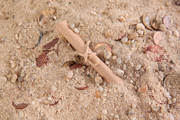 coins in the sand with message paper