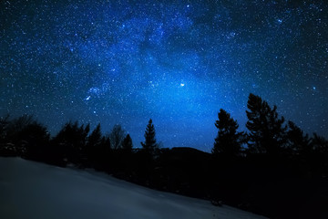 Milky Way in sky full of stars. Winter mountain landscape in night.