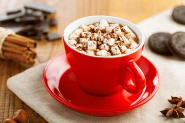 Cup of hot chocolate with marshmallow on table. Cocoa drink with sweet sandwich cookies.
