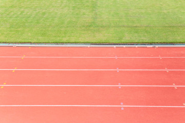 Athletics Track Lane or running track and green grass at football or soccer stadium.