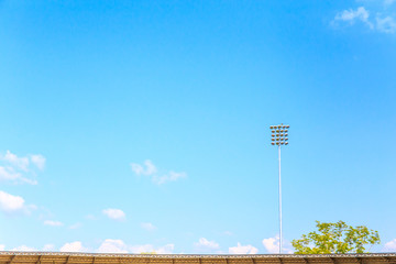 Fototapeta premium Lighting tower of stadium on sky and cloud background.