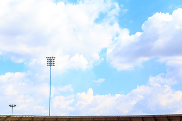 Lighting tower of stadium on sky and cloud background.