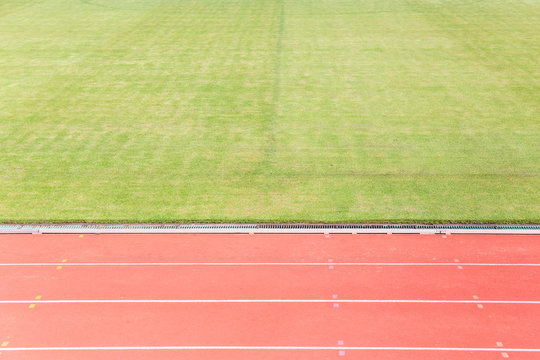 Athletics Track Lane or running track and green grass at football or soccer stadium.