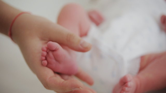 Baby legs. Legs newborn in parents hand