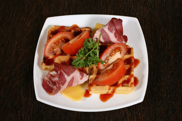 appetizer of bacon and baking in a sauce with tomatoes and chees