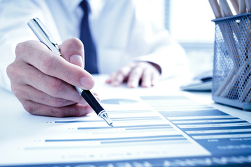 Fototapeta premium Businessman analyzing investment charts with laptop. Accounting