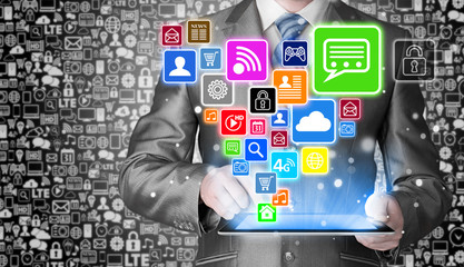 Obraz premium Business man using tablet PC with social media icon set