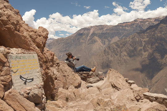 Young woman photographing condors in Colca, Arequipa, Peru