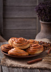 Sweet cinnamon bun rolls christmas scandinavian delicious sweet dough iced dessert on vintage woonde table. Traditional swedish kanelbullar baked pastry
