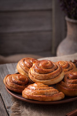 Sweet cinnamon bun rolls christmas scandinavian delicious sweet dessert on vintage woonde table. Traditional swedish kanelbullar baked pastry