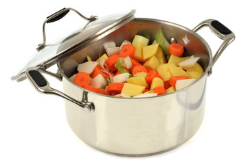 Faitout avec des pommes de terre, carottes, navets et poireaux coupés en morceaux 