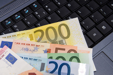 Money euro banknotes over laptop keyboard