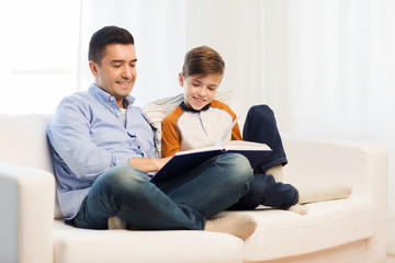 happy father and son reading book at home