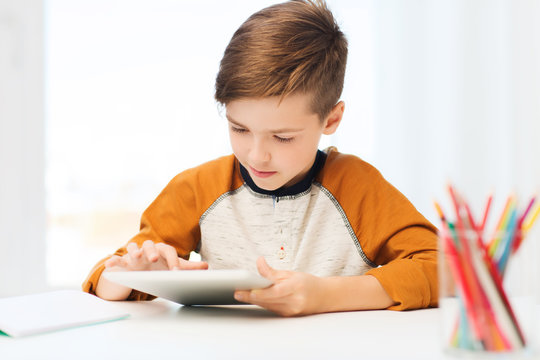 close up of boy with tablet pc computer at home