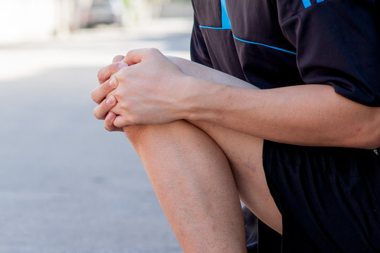 Runner touching painful knee. Athlete runner training accident. Sport running knee sprain.