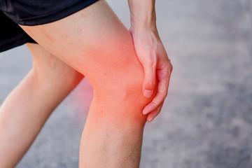 Runner touching painful knee. Athlete runner training accident. Sport running knee sprain.