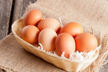 Eggs in Wicker basket on a wooden background
