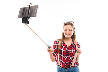 Long-haired girl with selfie stick taking photo