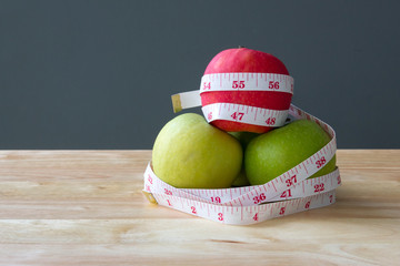 three apples red and green with measuring tape. diet concept, healthy slim