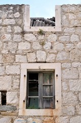 Wall of abandoned, damaged, old house with two windows