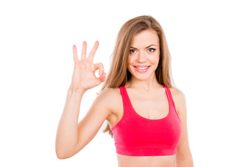 Sporty pretty young girl shows gesture "OK"