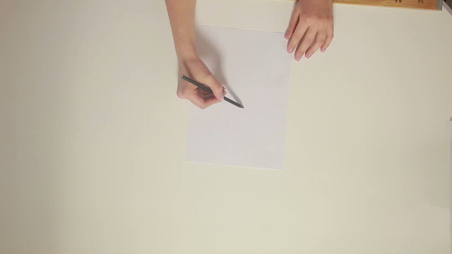 Female fashion designer drawing sketches for clothes in atelier.