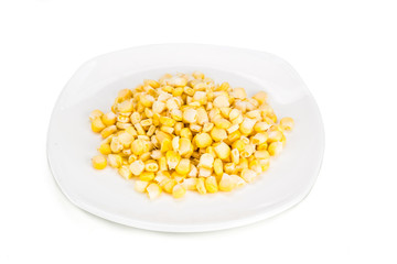 Fresh maize corn kernels on plate against white background
