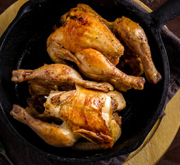 Christmas Roasted whole chicken in iron skillet, dark texture background. Close up