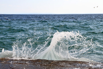 Breaking on stone pier splashing waves