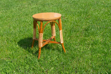 Used handmade wicker stool on a green spring grass